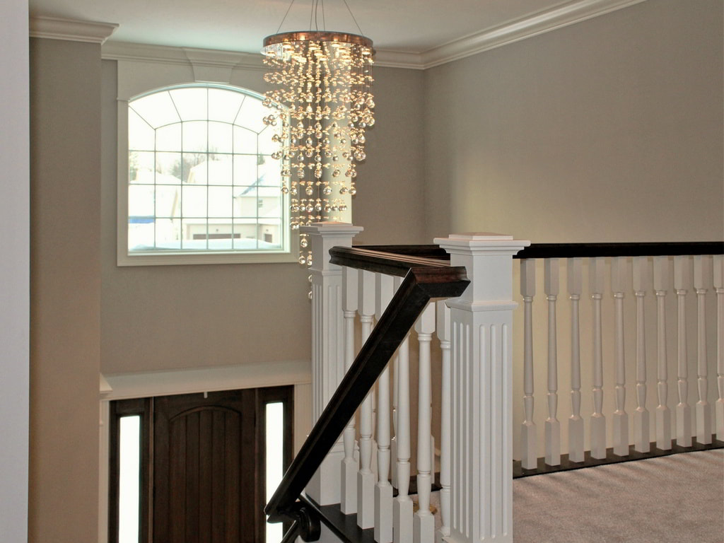 Modern Grand Foyer with Two-Story Ceiling, European Glass Chandelier, and Solid-Wood Stairway Built Exclusively by Morgan Homes of Western New York, Inc.